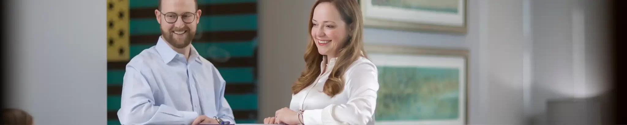 Two smiling lawyers from our team, both looking at something