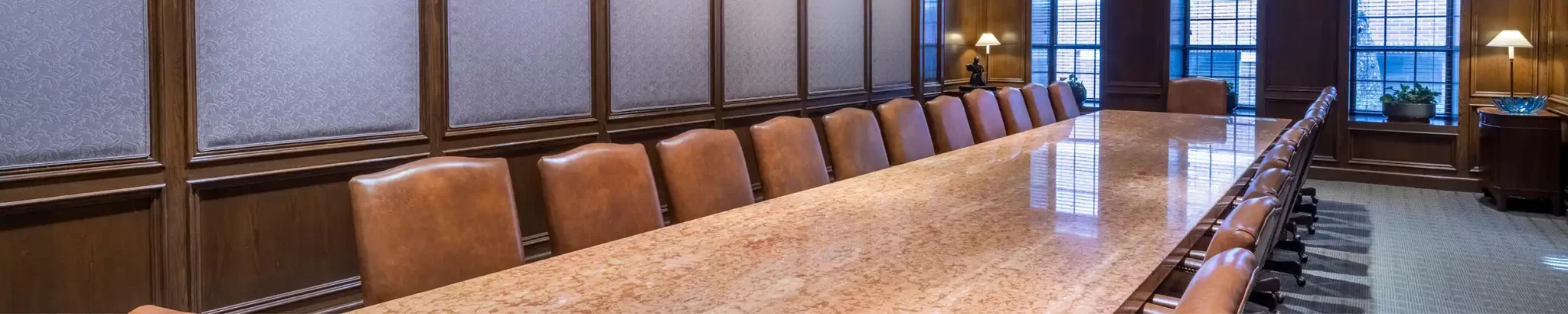A very long, shiny meeting table with chairs in an office